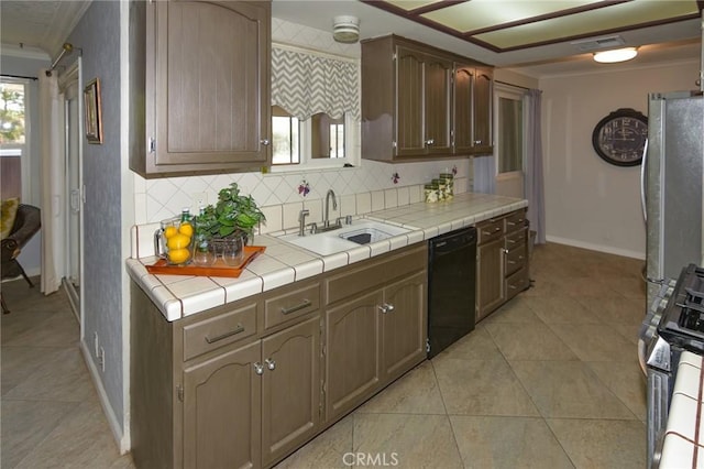 kitchen with crown molding, tile countertops, visible vents, a sink, and dishwasher