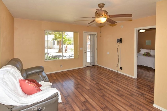 living area featuring ceiling fan, wood finished floors, and baseboards