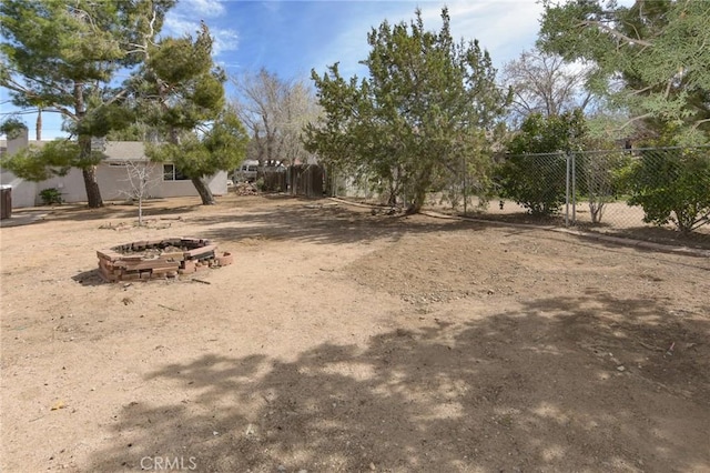 view of yard featuring a fire pit and fence