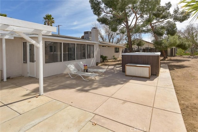 view of patio / terrace featuring central AC unit, fence, a sunroom, and a hot tub