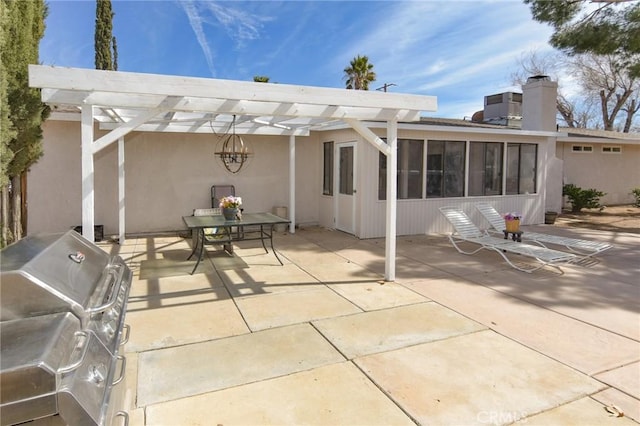 view of patio with grilling area, a sunroom, and a pergola