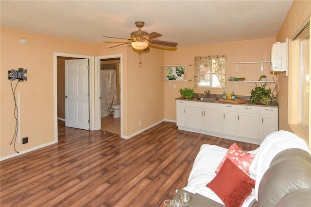 living room featuring dark wood-style floors, a ceiling fan, and baseboards