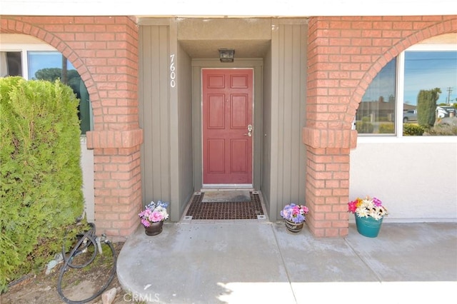 view of exterior entry featuring brick siding