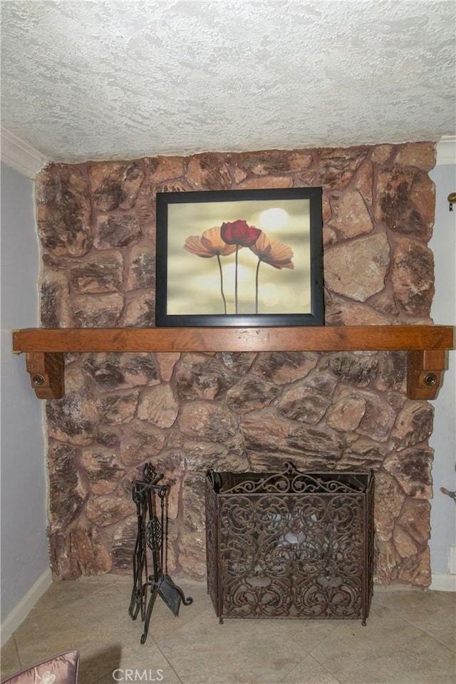 details featuring a textured ceiling, ornamental molding, a fireplace, and baseboards