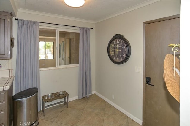 entryway featuring ornamental molding, baseboards, and light tile patterned floors