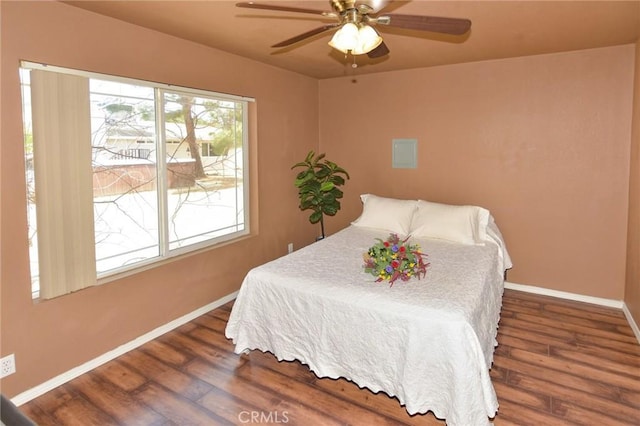 bedroom featuring wood finished floors, a ceiling fan, and baseboards