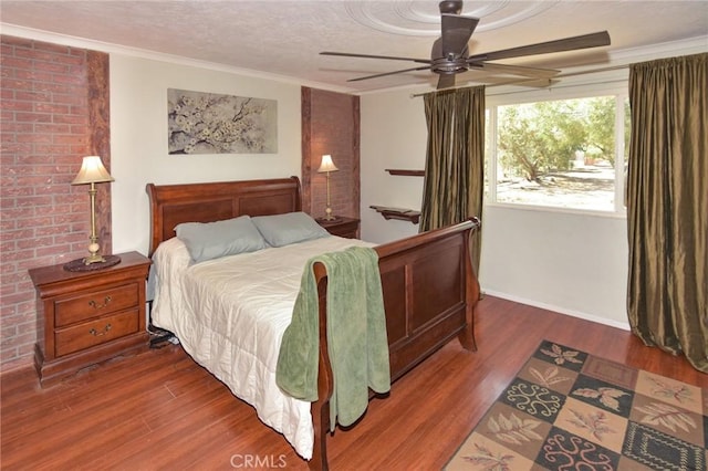 bedroom with a textured ceiling, ceiling fan, wood finished floors, and crown molding