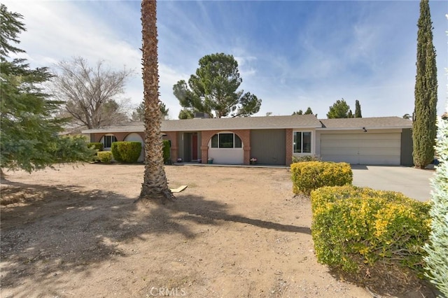 single story home featuring a garage, concrete driveway, and brick siding