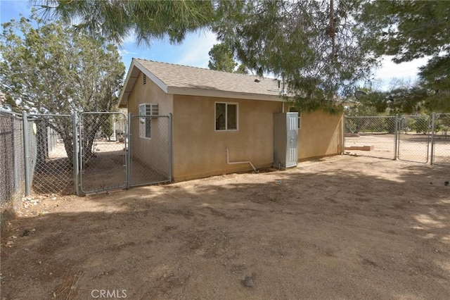 view of home's exterior featuring a gate, fence, and stucco siding