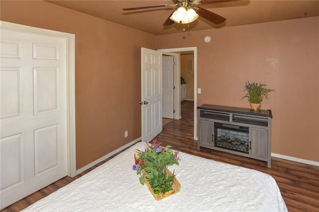 bedroom with wood finished floors, a ceiling fan, and baseboards