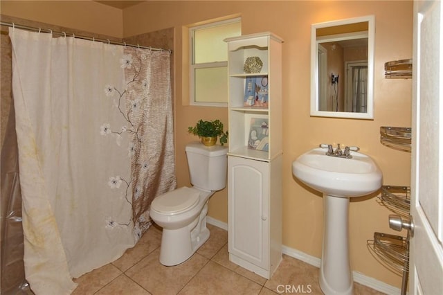 bathroom featuring curtained shower, tile patterned flooring, toilet, and baseboards