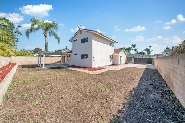 rear view of house featuring a patio area, a fenced backyard, and stucco siding