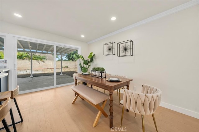 dining room featuring baseboards, light wood finished floors, recessed lighting, and crown molding