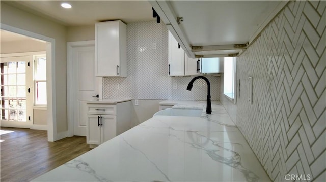 3688 Hoover St, Riverside, CA 92504 - kitchen featuring light stone counters, white cabinets, wood finished floors, a sink, and baseboards