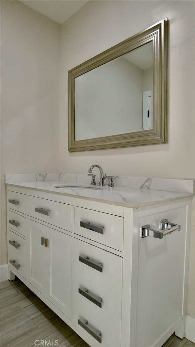 bathroom with wood finished floors and vanity