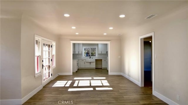 unfurnished room with a sink, baseboards, and wood finished floors