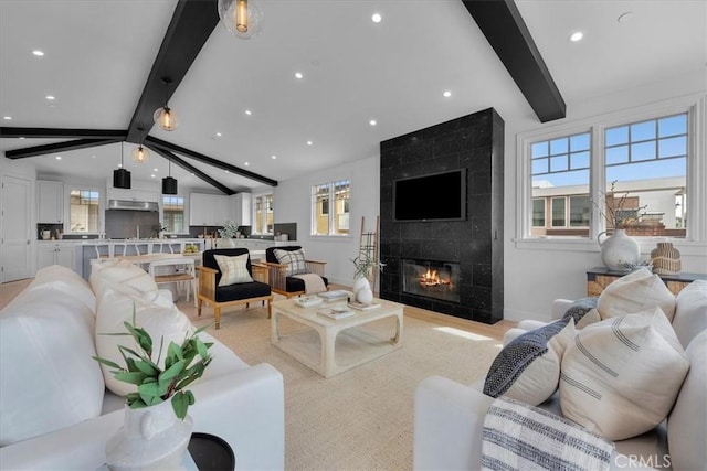 living area featuring vaulted ceiling with beams, recessed lighting, a fireplace, and baseboards