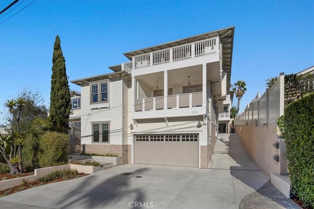 view of front facade with french doors, brick siding, concrete driveway, a balcony, and a garage