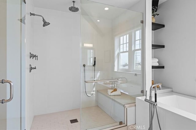 full bath featuring a stall shower, a bathtub, and recessed lighting