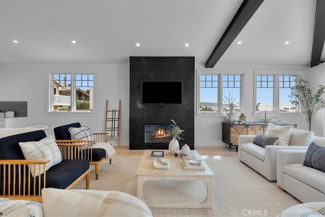 living area with baseboards, light wood-style flooring, a fireplace, beam ceiling, and recessed lighting