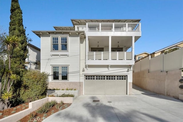 view of front facade with a garage, concrete driveway, brick siding, and a balcony