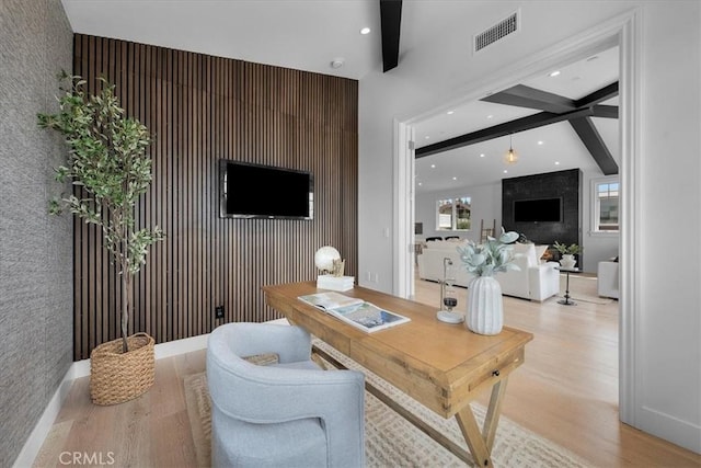 office space with light wood finished floors, visible vents, an accent wall, beam ceiling, and recessed lighting