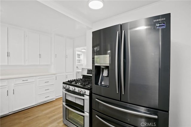 kitchen with stainless steel appliances, light countertops, white cabinetry, and light wood-style floors