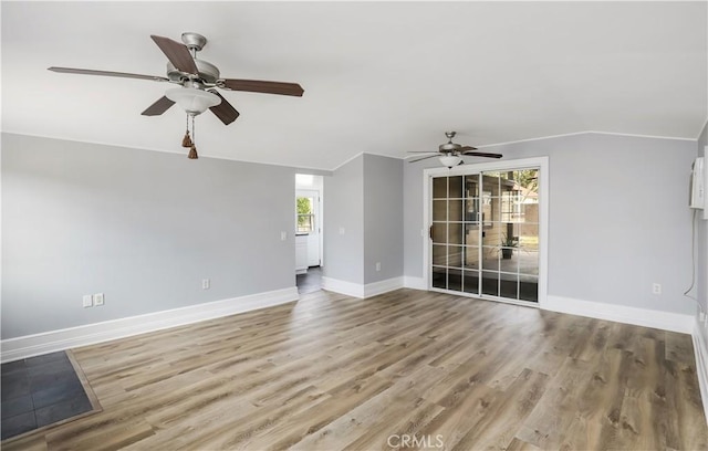 spare room featuring ceiling fan, light wood-style flooring, baseboards, and vaulted ceiling