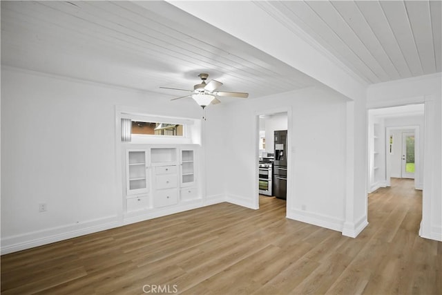 spare room featuring wood finished floors, wood ceiling, a ceiling fan, baseboards, and ornamental molding