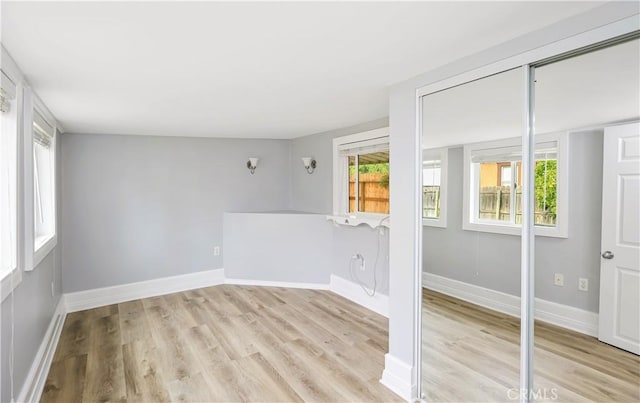 unfurnished room with baseboards and light wood finished floors