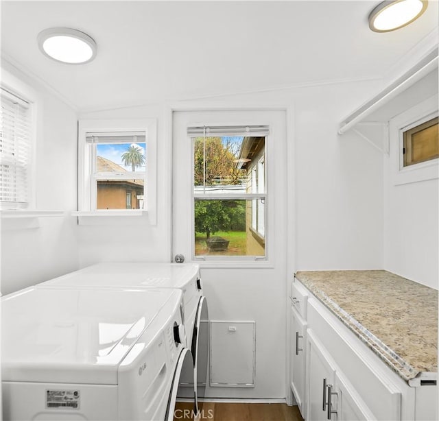 washroom with washing machine and dryer, cabinet space, and dark wood finished floors