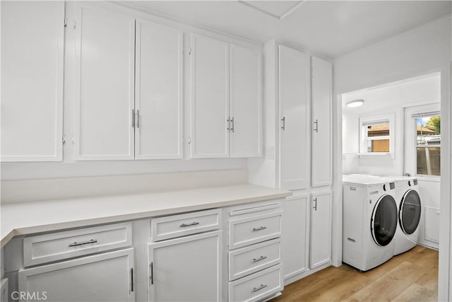 clothes washing area featuring light wood-type flooring, laundry area, and washing machine and dryer