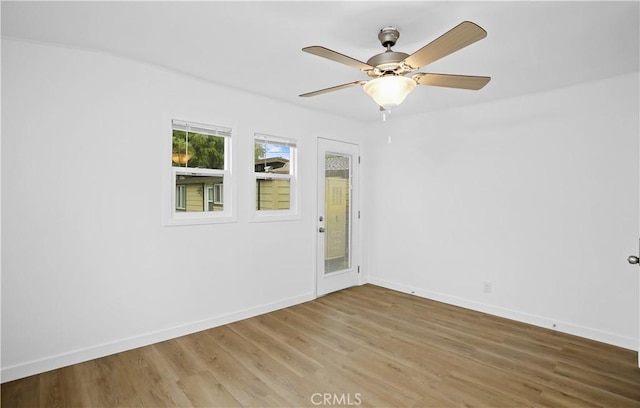 unfurnished room with ceiling fan, wood finished floors, and baseboards