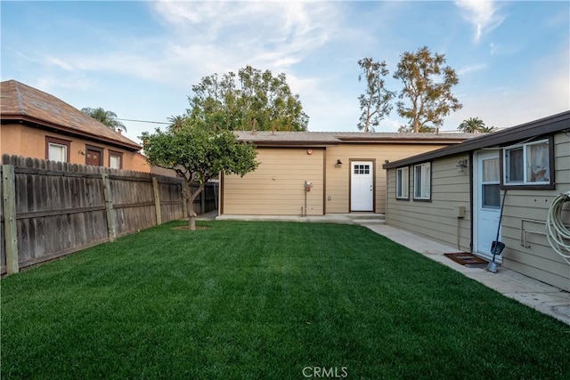 back of property with fence and a yard