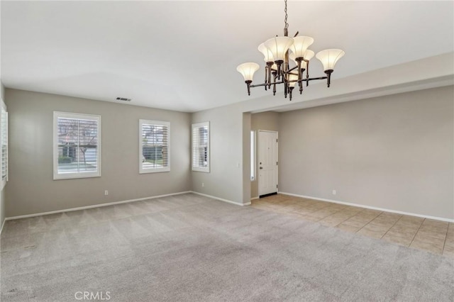 carpeted spare room with visible vents, a chandelier, baseboards, and tile patterned floors