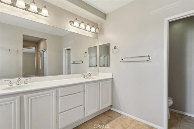 full bath with tile patterned flooring, a sink, and baseboards