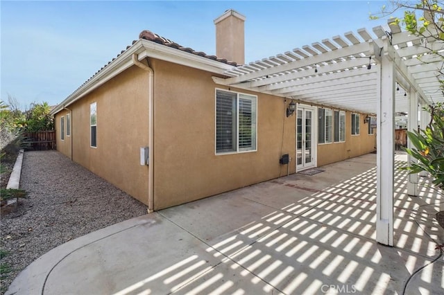 back of property with a pergola, a patio area, fence, and stucco siding