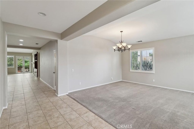 empty room featuring light tile patterned floors, visible vents, baseboards, light colored carpet, and a chandelier