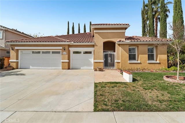 mediterranean / spanish-style house featuring a tiled roof, an attached garage, and stucco siding