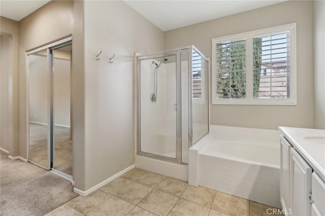 full bath featuring a stall shower, baseboards, tile patterned flooring, vanity, and a bath