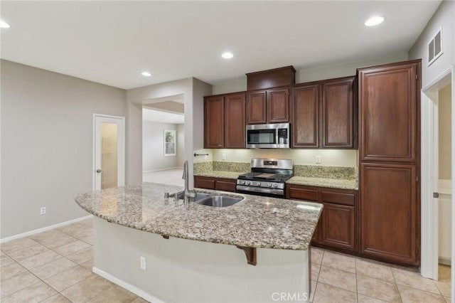 kitchen with visible vents, stainless steel appliances, a sink, and light tile patterned flooring