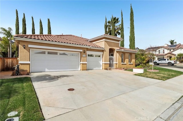 mediterranean / spanish-style home featuring an attached garage, driveway, fence, and stucco siding