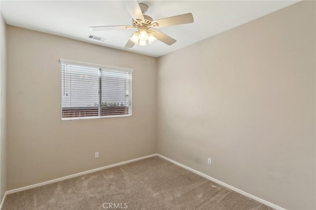 carpeted spare room with a ceiling fan, visible vents, and baseboards