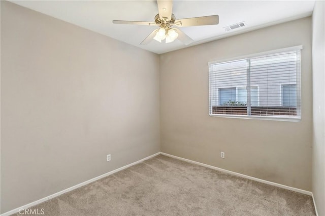 spare room featuring a ceiling fan, carpet, visible vents, and baseboards