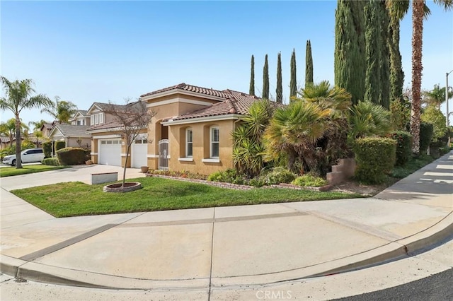 view of front facade with driveway, a tiled roof, an attached garage, a front lawn, and stucco siding