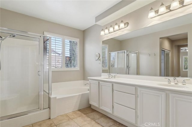 bathroom featuring double vanity, a garden tub, a shower stall, and a sink