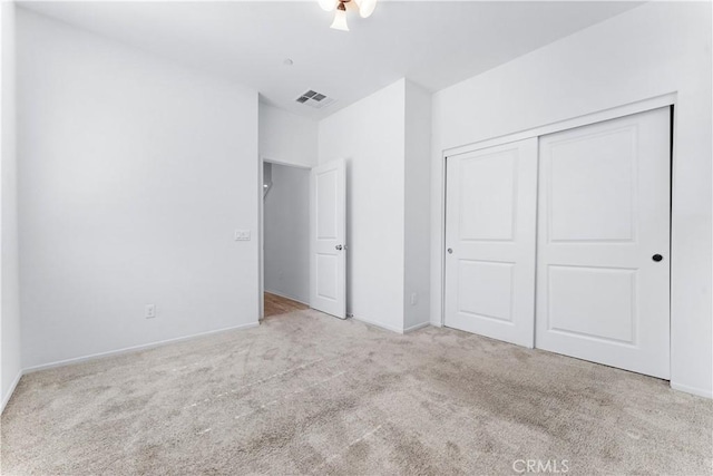 unfurnished bedroom featuring a closet, carpet flooring, visible vents, and baseboards