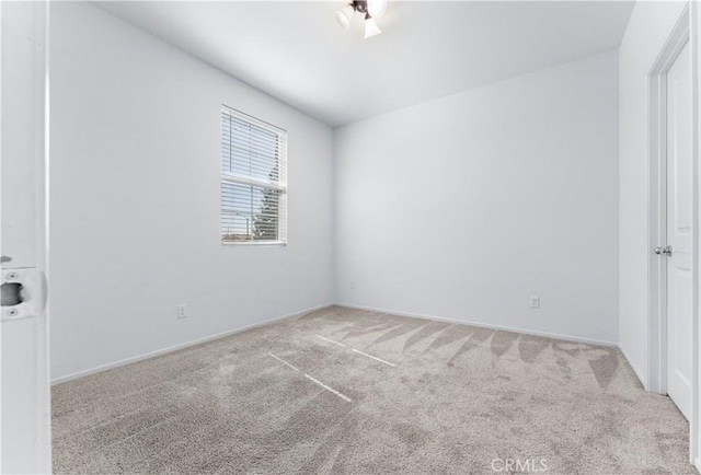 carpeted spare room with baseboards