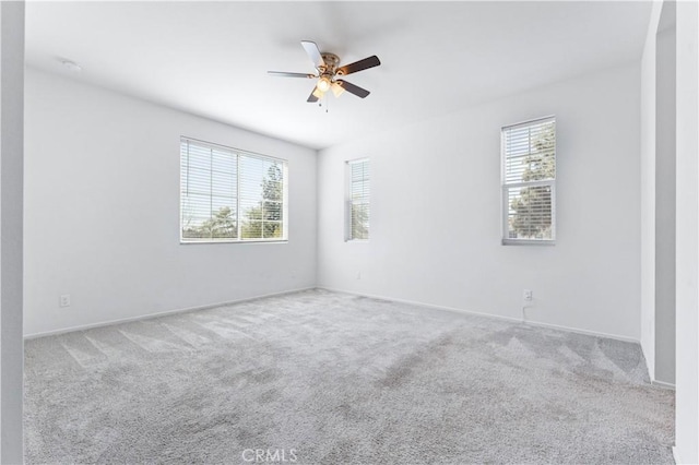 unfurnished room featuring carpet floors, a ceiling fan, and a healthy amount of sunlight