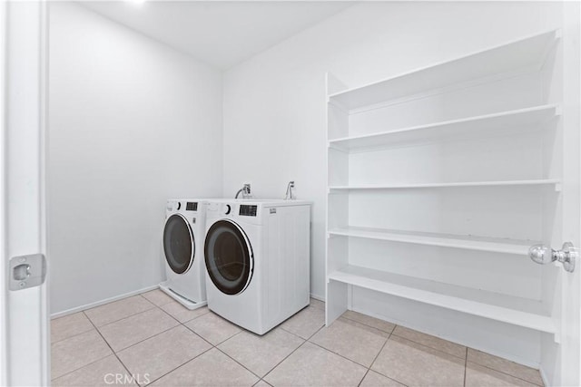 washroom featuring light tile patterned floors, laundry area, and separate washer and dryer